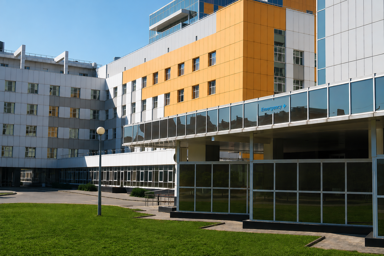 Modern hospital building exterior with emergency entrance and landscaped grounds